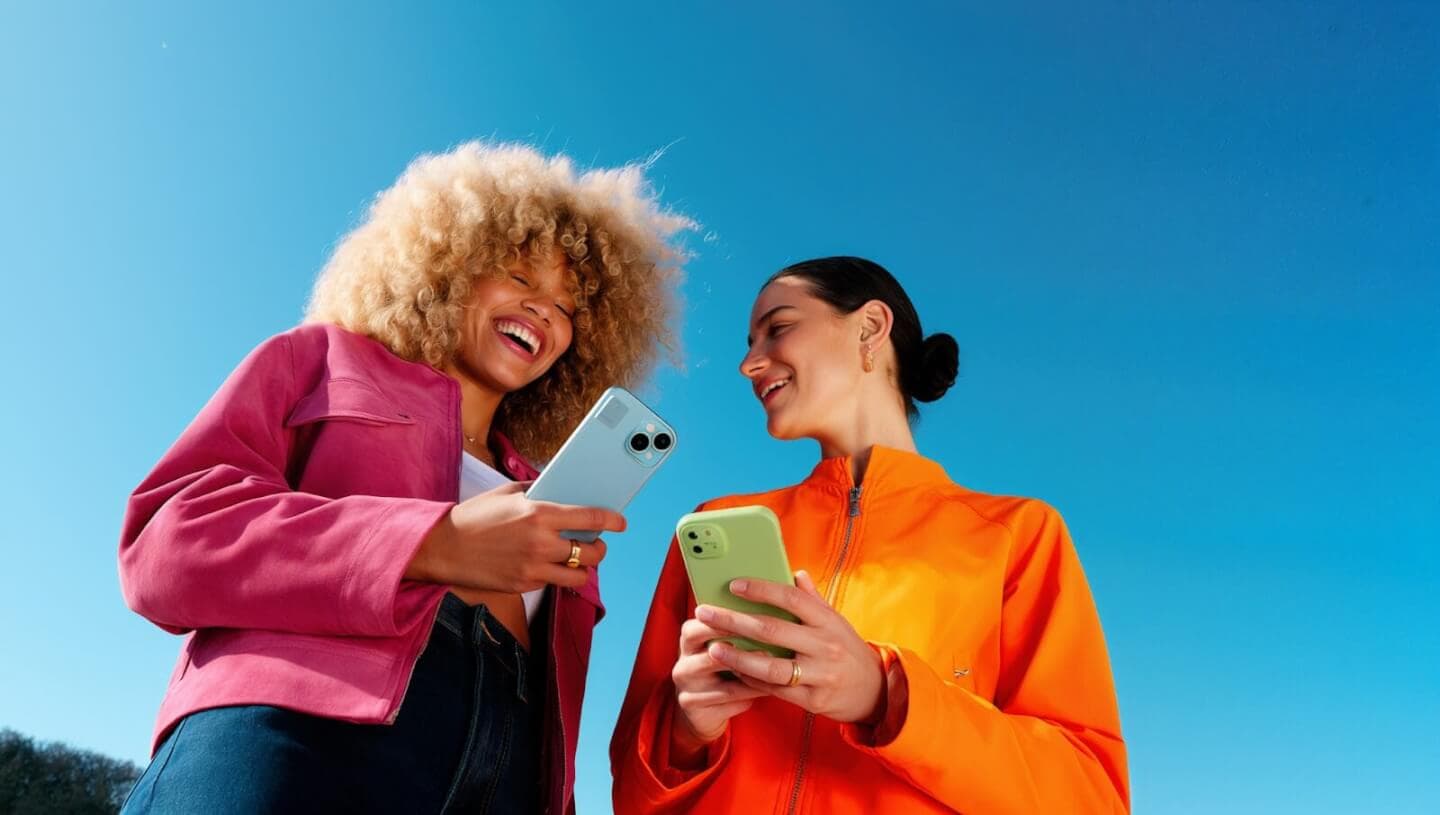 Duas pessoas se divertindo enquanto olham seus celulares